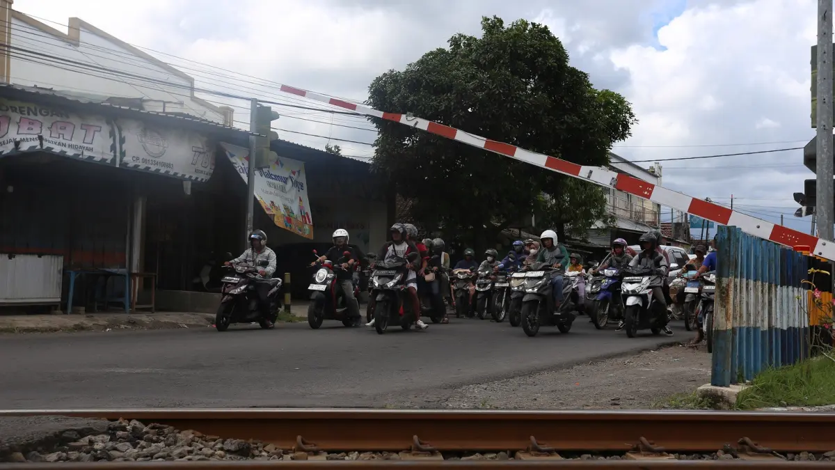 ATUR DENGAN BAIK: Pada saat rel kereta api lewat, ini menambah kemacetan yang terjadi di sekitar Perempatan Mangli. (YULIO FA/RADAR JEMBER)