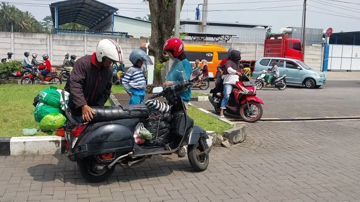 NAIK VESPA: Pemudik dari arah Banyuwangi berhenti di halaman SPBU Garahan, Kecamatan Silo. (JUMAI/RADAR JEMBER)