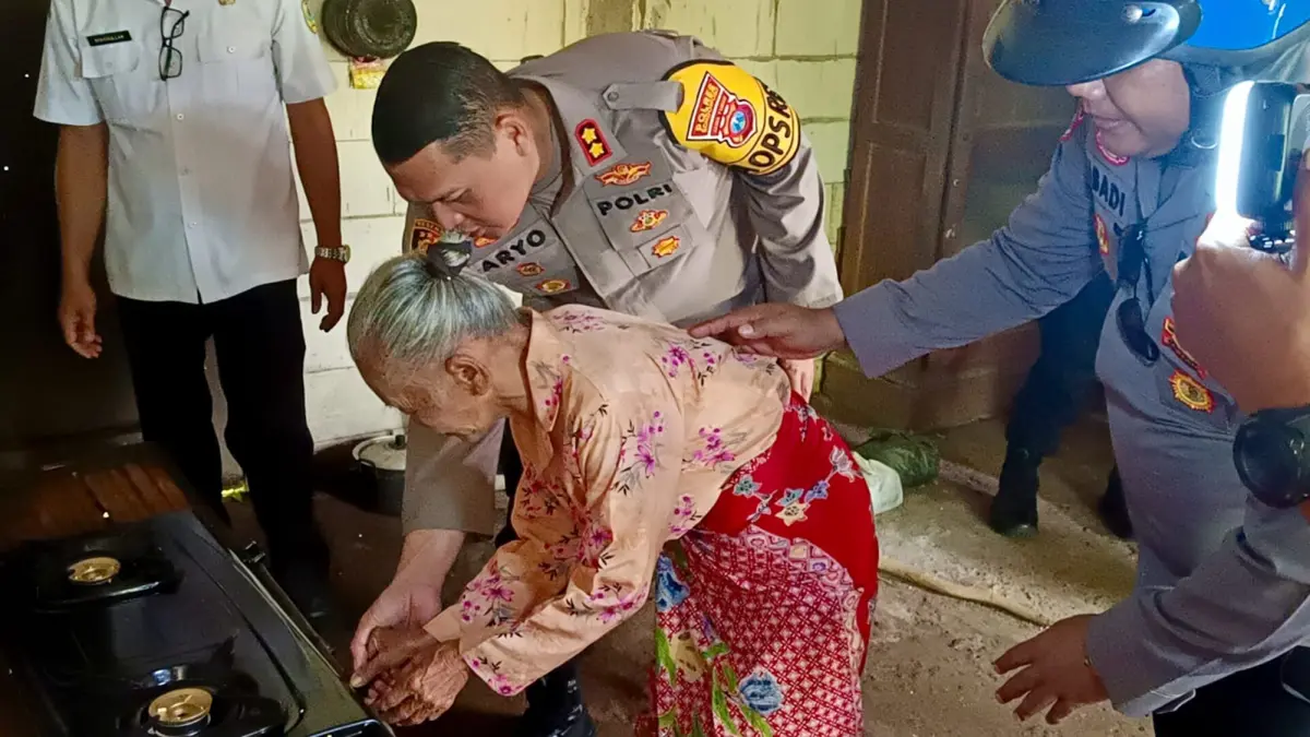 BERBAGI: Kapolres Bondowoso, AKBP Dr Aryo Dwi Wibowo memandu Ibu Lima menyalakan kompor yang baru diberikan kepadanya.