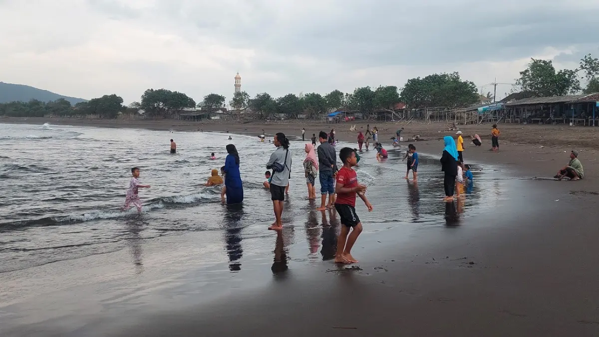 HATI-HATI: Pengunjung Pantai Payangan, Dusun Watu Ulo, Desa Sumberejo, Kecamatan Ambulu untuk tetap waspada ombak besar. (JUMAI/RADAR JEMBER)