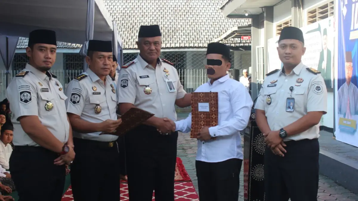 SEDERHANA: Kalapas Bondowoso, Nunus Ananto (tengah) memberikan SK Remisi Khusus Hari Raya Idul Fitri kepada salah seorang warga binaan. (ISTIMEWA)