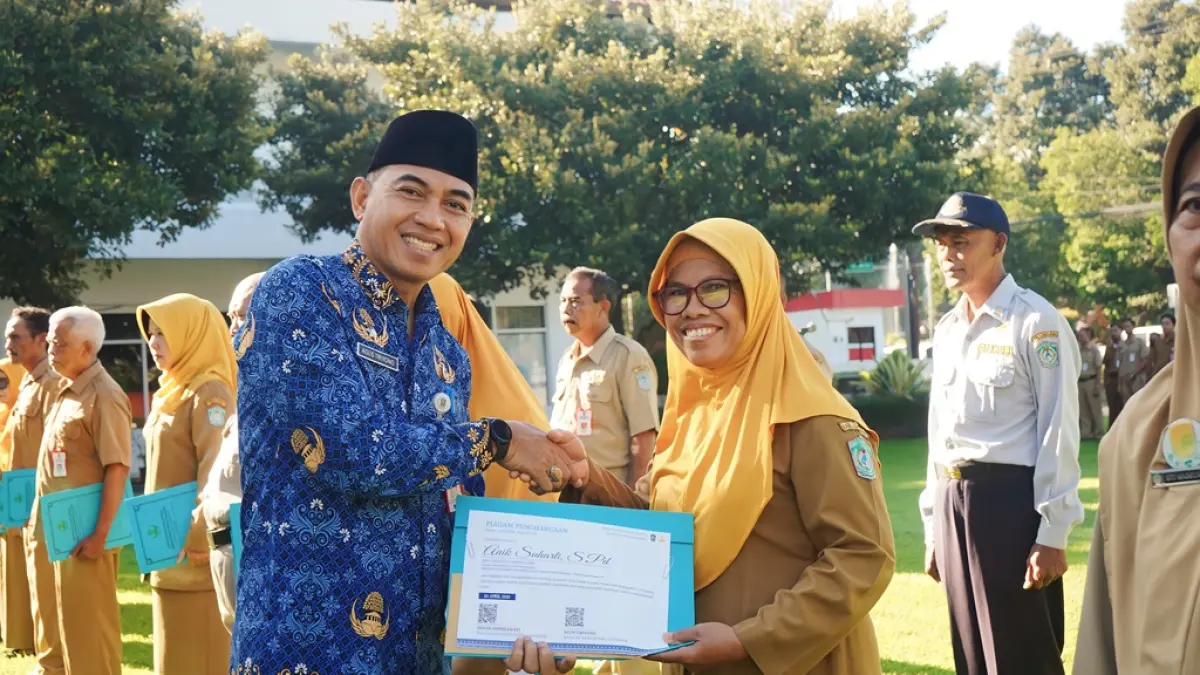 SERAHKAN : Sekretaris Daerah Kabupaten Lumajang, Agus Triyono, saat menyerahkan piagam penghargaan purna ASN, kemarin.
