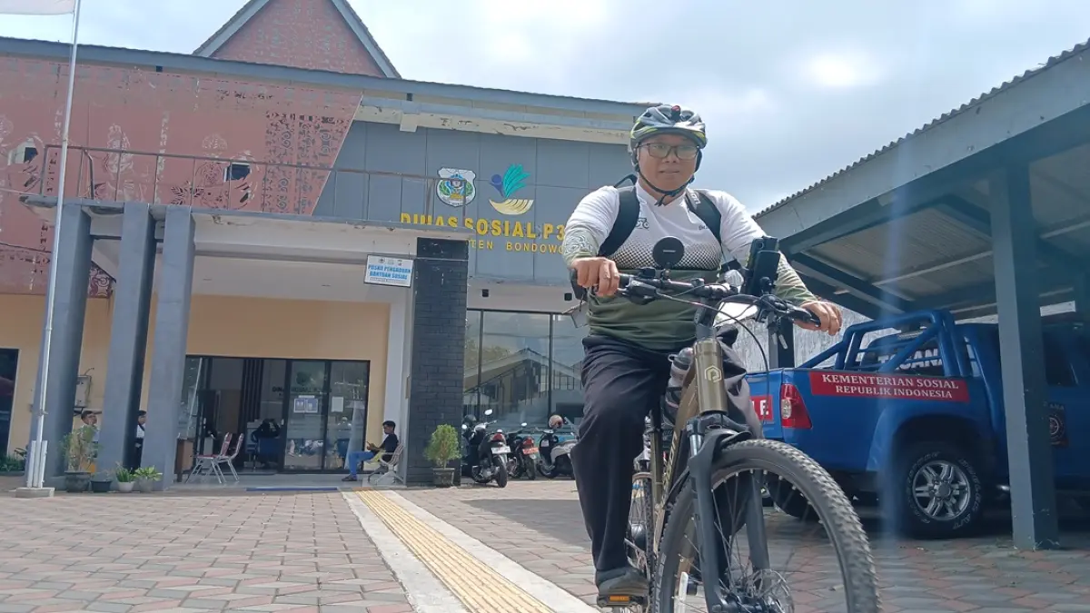 BERSEMANGAT: Untung Khuzairi, Kabid Rehabilitasi Sosial, Dinas Sosial P3AKB Bondowoso bersiap mengayuh sepedanya. (ILHAM/RJ)