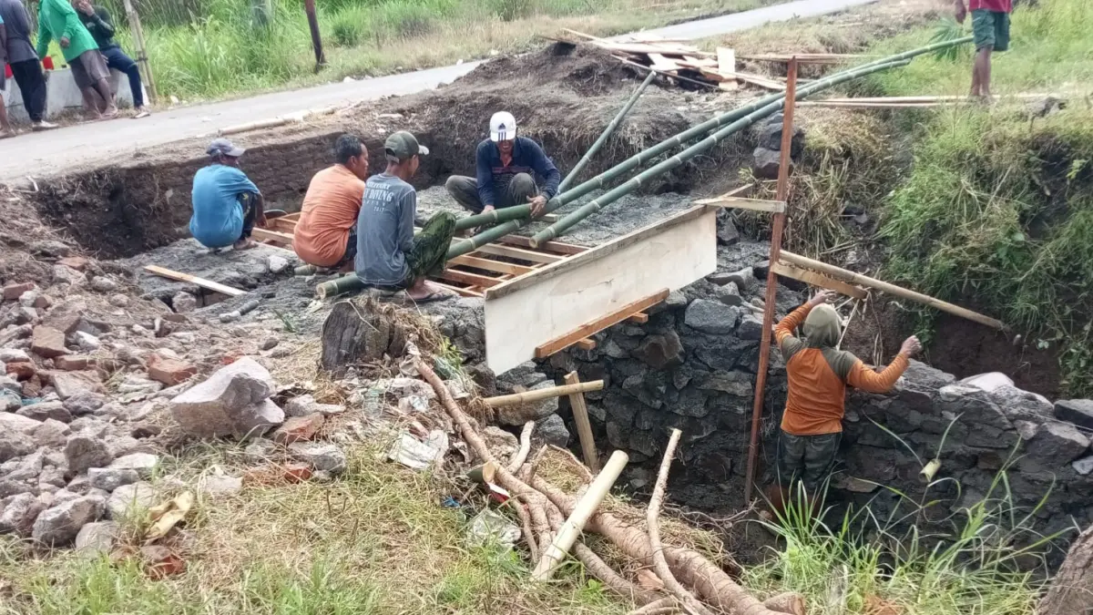 GOTONG ROYONG: Warga Curahtakir saat membangun pelebaran jembatan sekaligus jalan. Jembatan tersebut kini bisa dilalui dua truk sekaligus. (JUMAI/RADAR JEMBER)