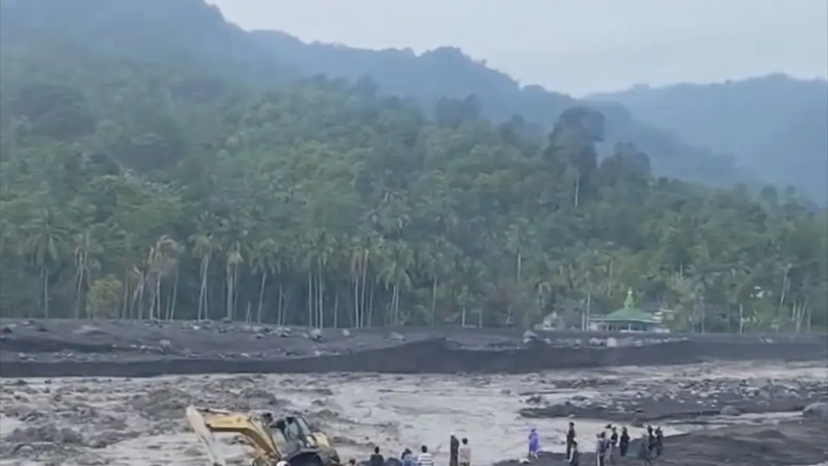 TERJEBAK: Sebuah alat berat terjebak banjir lahar dingin di kawasan Jembatan Kali Regoyo,
kemarin.