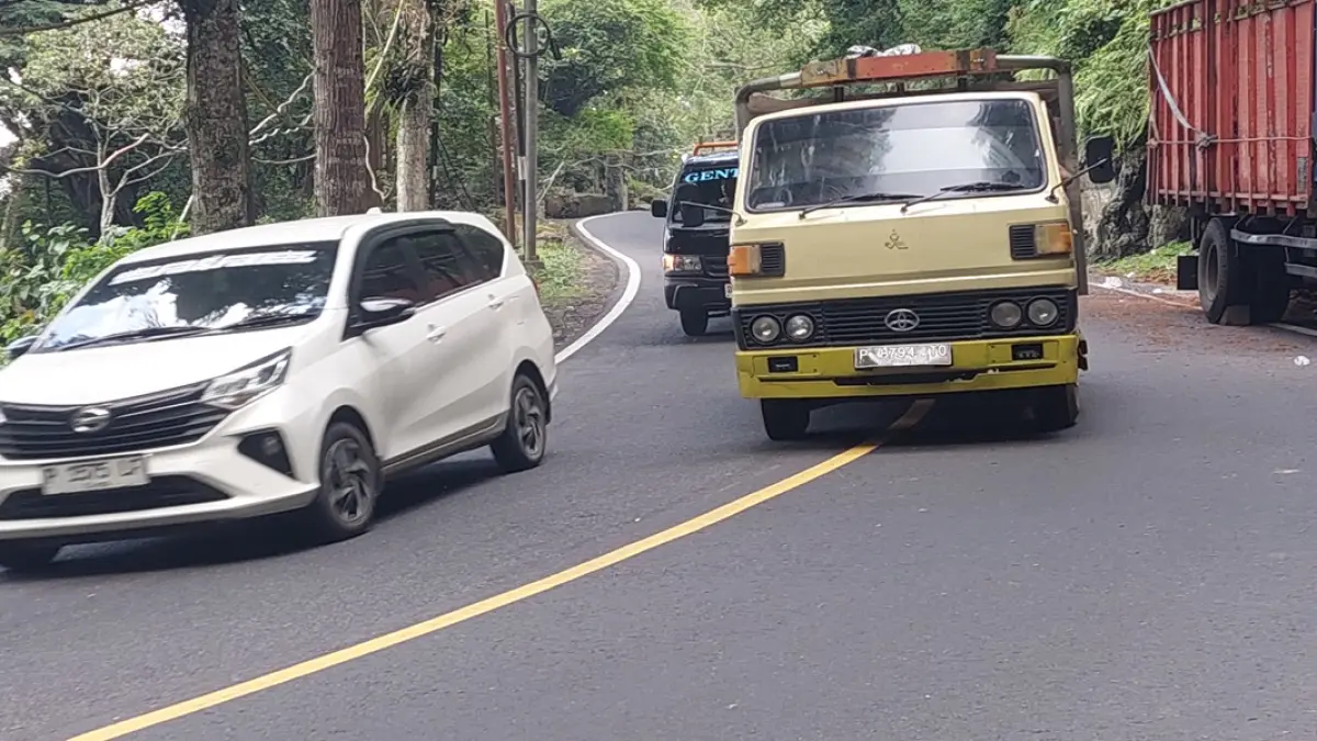 BERANI: Sopir mobil nekat mendahului truk di jalan menikung Gumitir. (JUMAI/RJ)