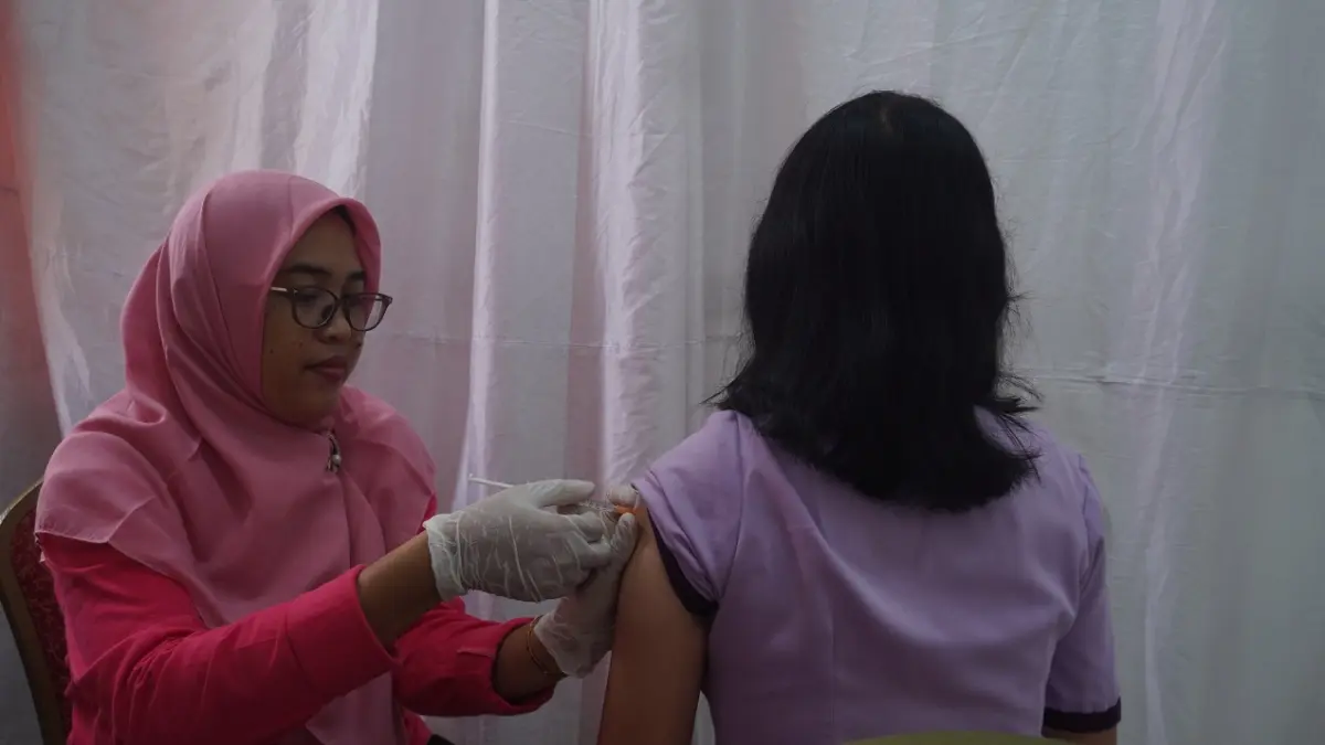 PENCEGAHAN: Warga Jember menerima vaksin HPV sebagai langkah pencegahan kanker serviks di Kantor PLUT DKUKMP Jember, Selasa (8/4). (SIDKIN ALI/RADAR JEMBER)