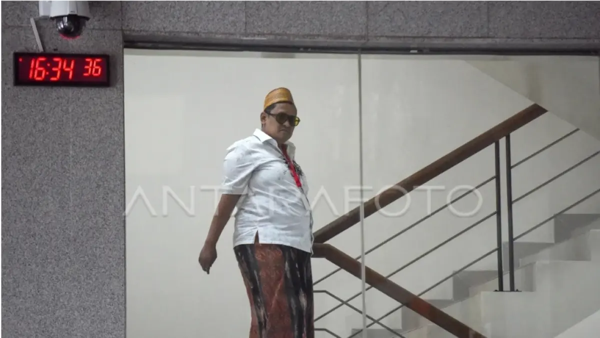 BERJALAN: Haji Her saat menurni tangga gedung merah putih usai menjalani lemerikaan (ft:ANTARA)