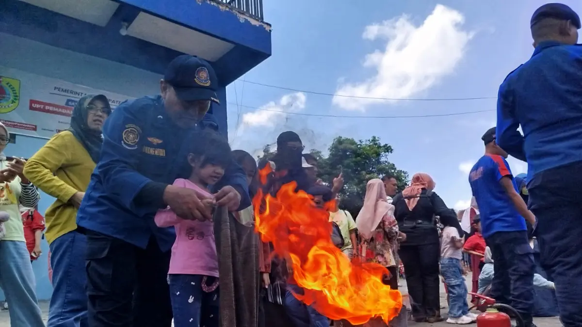 EDUKASI API: Petugas Damkarmat Satpol PP Jember mengedukasi anak-anak cara menangani api. (DWI SISWANTO/RADAR JEMBER)