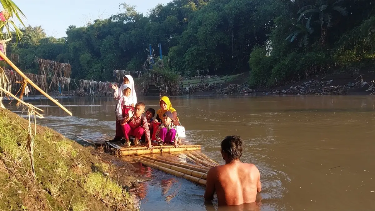 &nbsp;TERPAKSA NAIK GETEK: Sejumlah siswa SD dan TK di Desa Jubung, Kecamatan Sukorambi, menyeberangi Sungai Bedadung menggunakan getek untuk berangkat sekolah. Kondisi itu terjadi akibat jembatan gantung yang putus sejak Februari 2026 lalu. (JUMAI/RADAR JEMBER)