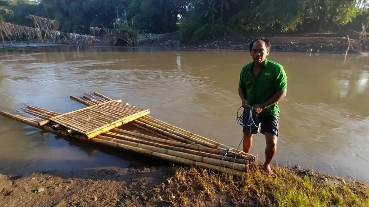 PEDULI:&nbsp;Muhammad Soleh menarik getek bambu dengan cara berenang untuk bisa menyeberangkan warga melewati di Sungai Bedadung, Desa Jubung, Kecamatan Sukorambi. (JUMAI/RADAR JEMBER)