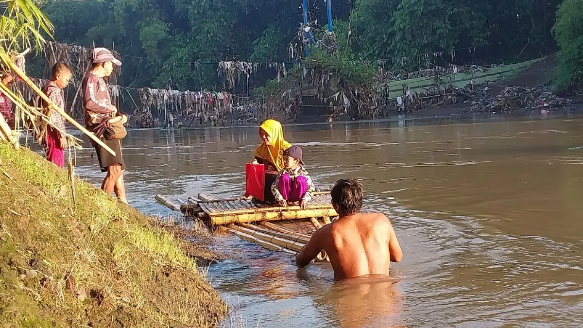 BERTARUH NYAWA: Sejumlah anak sekolah yang terpaksa menyeberangi derasnya arus Sungai Bedadung menggunakan getek di Desa Jubung, Kecamatan Sukorambi. (JUMAI/RADAR JEMBER)