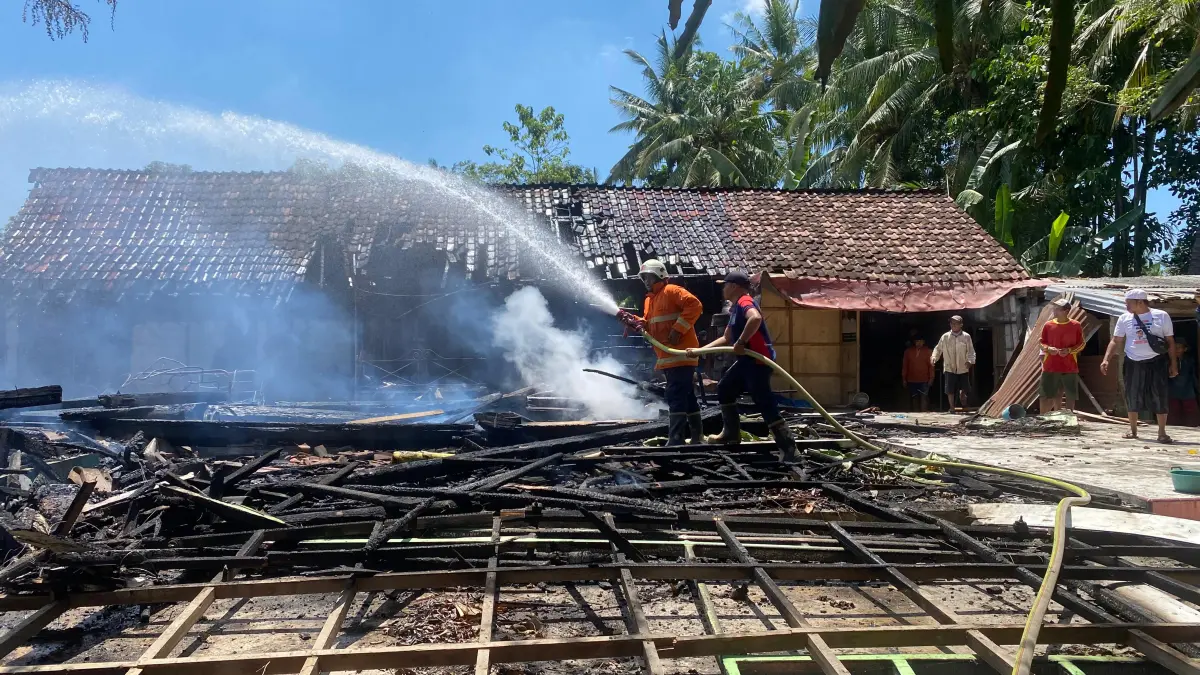 DIPADAMKAN: Sejumlah petugas Damkar saat berusaha memadamkan api yang membakar rumah warga, (15/4). (DAMKAR BWS)