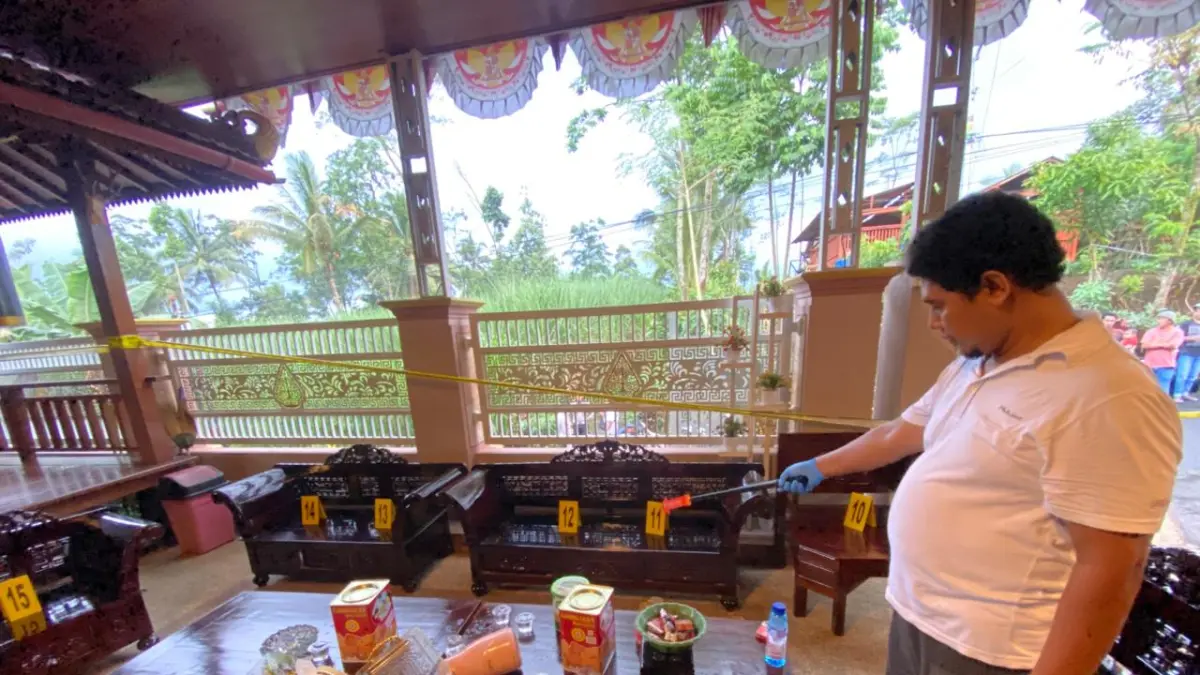 PERIKSA: Sejumlah anggota kepolisian sedang melakukan olah tempat kejadian perkara di
rumah Kades Pakel, Kecamatan Gucialit, kemarin