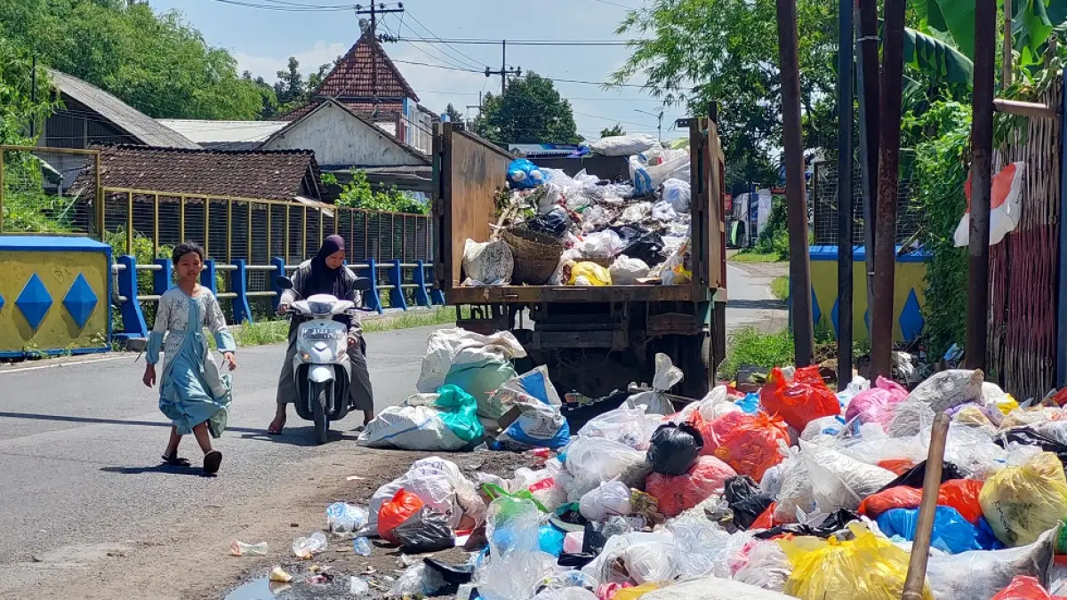 MENUNGGU TRUK DATANG: Warga menunggu truk sampah datang untuk membuang sampah ke TPS, Dusun Bedengan, Desa Tegalsari, Kecamatan Ambulu. (JUMAI/RADAR JEMBER)