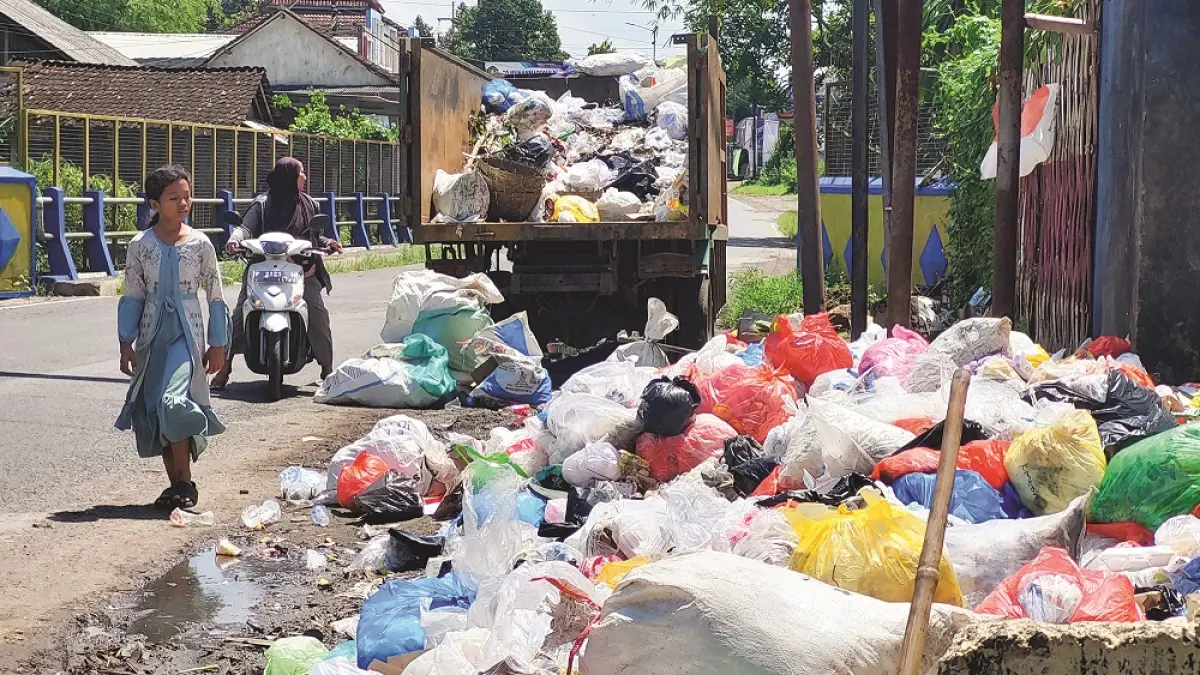  Warga menunggu truk sampah datang untuk membuang sampah ke TPS, Dusun Bedengan, Desa Tegalsari, Kecamatan Ambulu. (JUMAI/RADAR JEMBER)