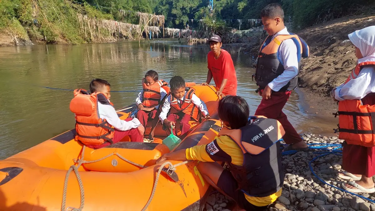 TETAP SEMAMGAT: Kondisi sejumlah siswa SDN Jubung 02, yang rumahnya berada di Dusun Darungan Utara Desa Jubung, Kecamatan Sukorambi terpaksa menyeberang sungai menggunakan perahu karet. (JUMAI/RADAR JEMBER)