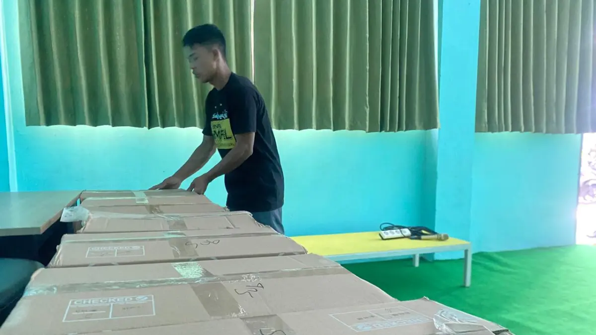 DIBERIKAN: Petugas kementerian haji dan umroh Bondowoso, menyiapkan koper untuk diberikan kepada Calon Jemaah Haji. (ILHAM/RJ)