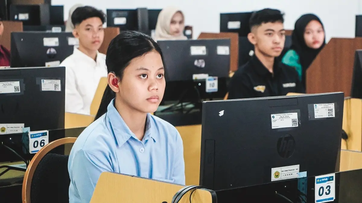 KEREN: Carissa Vania Artamevira, peserta penyandang disabilitas pendengaran menggunakan alat bantu dengar milik pribadi, saat mengikuti UTBK SNBT 2026 di Unej. (UNEJ)
