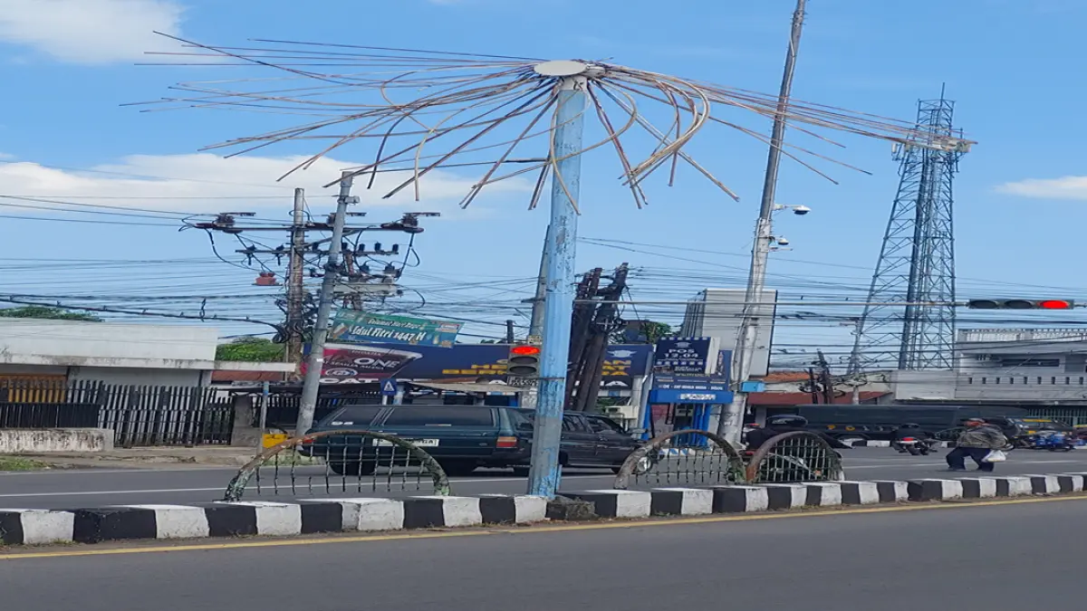 DIBIARKAN: Bekas lampu hias di jalur double way Jalan Letjen Panjaitan, Kelurahan/Kecamatan Sumbersari, kini hanya menyisakan sebagian tiang dan rangka bagian atas. (JUMAI/RJ)