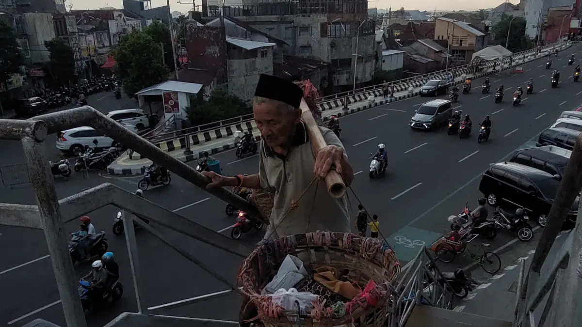 LEBIH AMAN: Seorang kakek yang hendak menuju Pasar Tanjung memilih menyeberang melalui Jembatan Penyeberangan Orang (JPO) demi keselamatan. (JUMAI/RJ)