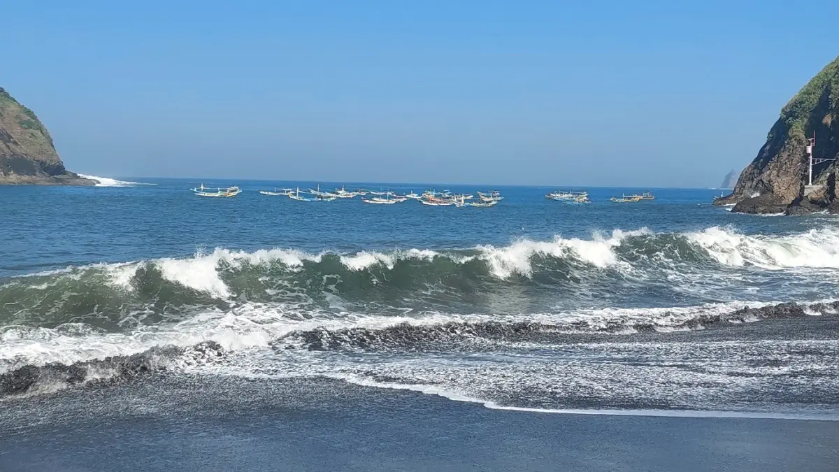TAK BISA PULANG: Puluhan jukung jenis speed milik nelayan Payangan diparkir di tengah laut sekitar Bukit Samboja, Desa Sumberejo, Kecamatan Ambulu, akibat ombak besar yang membuat perahu tak bisa bersandar ke tepi. (JUMAI / RADAR JEMBER)