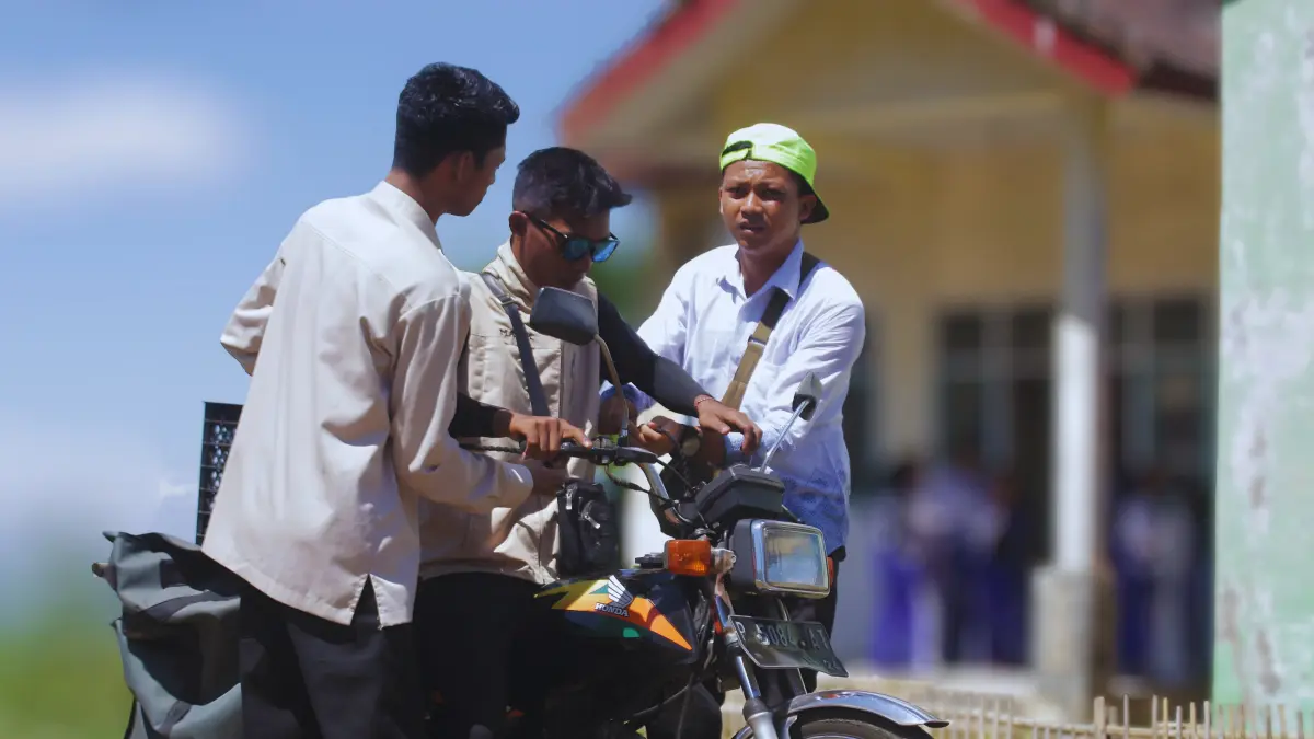 CERIA: Abdul Malik, petugas distribusi MBG SPPG Wringin II menyapa para siswa di SDN Banyuwulu 4, mereka tampak sudah akrab.(ILHAM WAHYUDI)