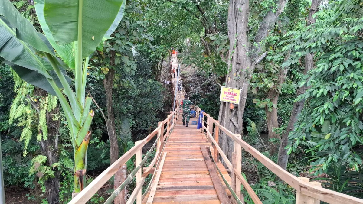 MENINJAU: warga saat menyaksikan kondisi jembatan darurat, kemarin (27/4). (FAQIH)

