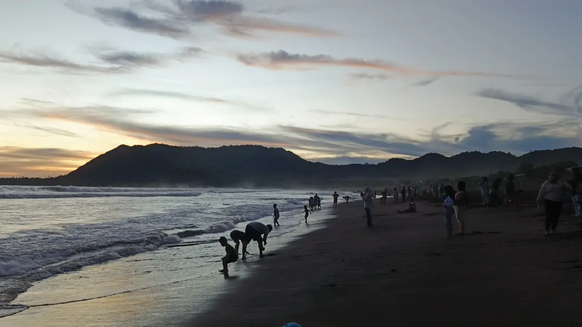 Panorama pantai Watu Ulo Jember saat menjelang senja dengan bentangan pasirnya yang berwarna hitam pekat. (Foto: Maulana/Radar Jember)