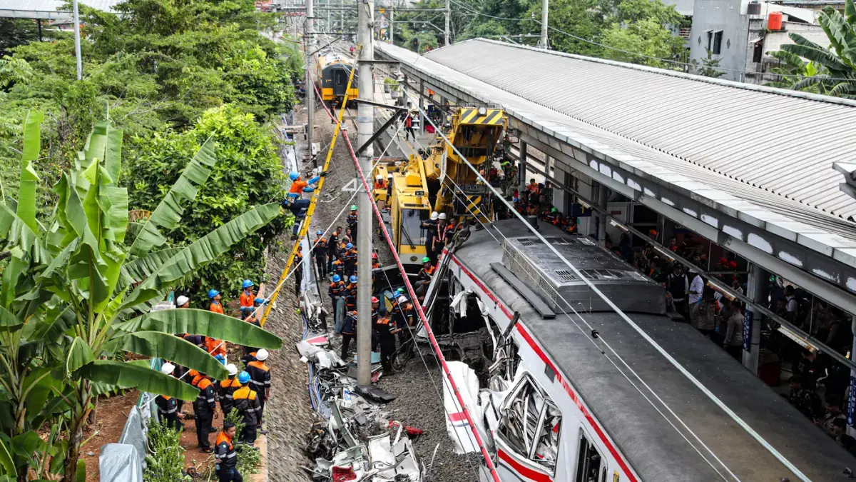 Petugas gabungan berkonsentrasi penuh melakukan pemotongan badan gerbong kereta dengan menggunakan crane. (Ryandi Zahdomo/ JawaPos.com)