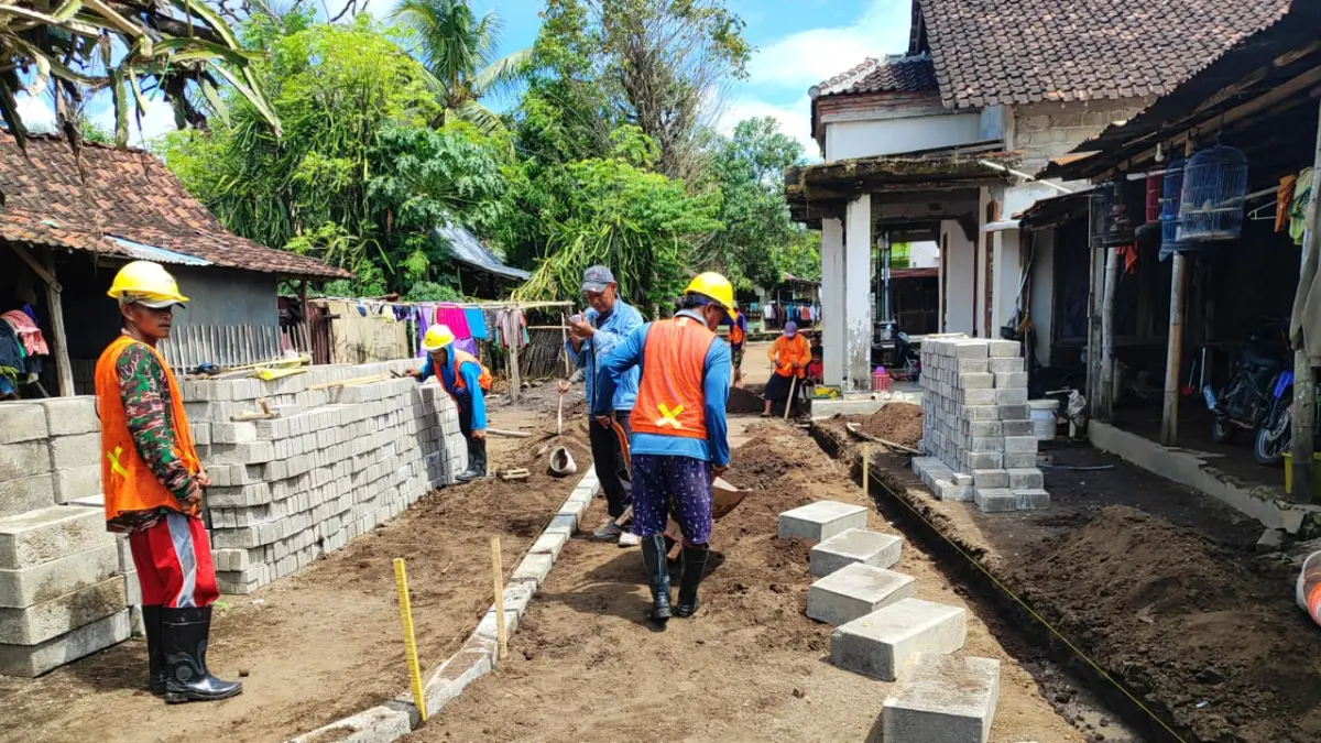 DIKERJAKAN: Para pekerja saat mengerjalan jalan lingkungan di salah satudesa sesuai program yang sudah digarap. (FAQIH HUMAINI)