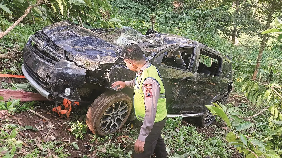 RINGSEK: Anggota kepolisian saat melakukan identifikasi mobil Suzuki XL-7 yang mengalami kecelakaan dan terjun ke jurang Gumitir, kemarin (7/5). (JUMAI/RADAR JEMBER)