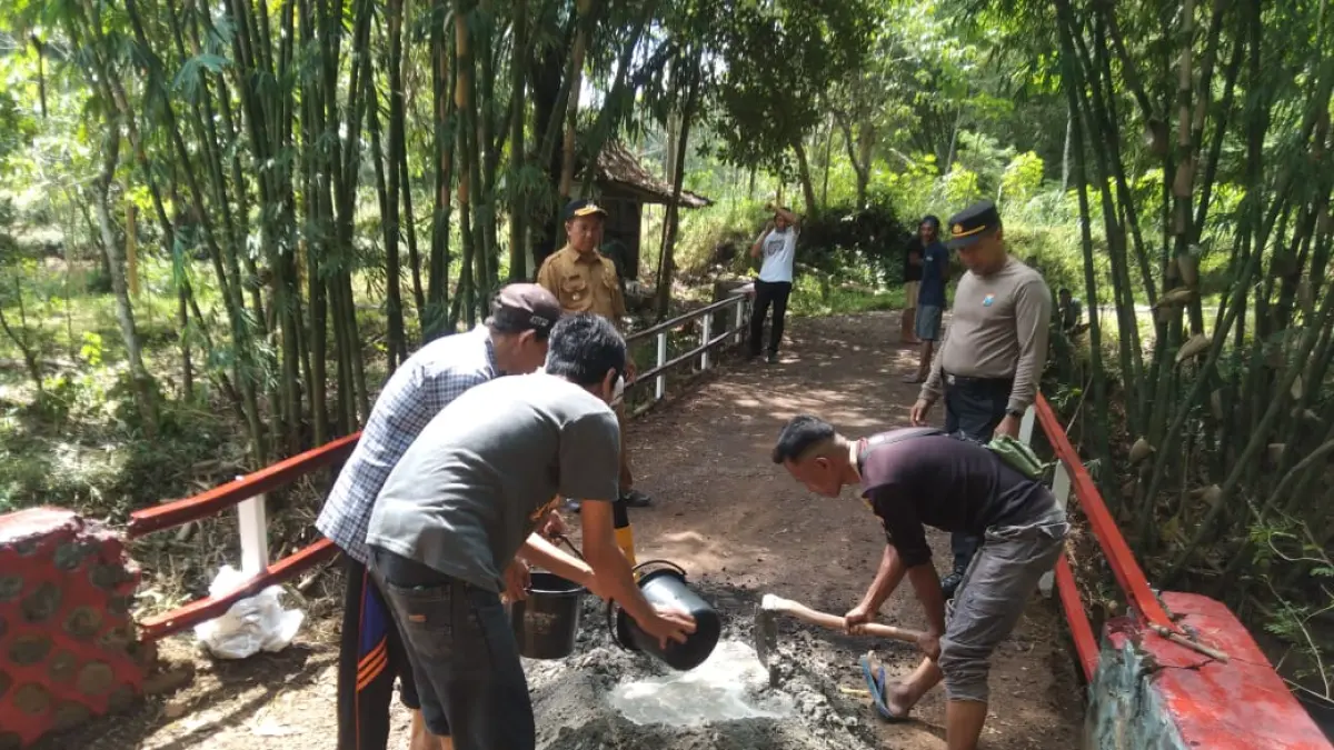 KOMPAK: Sejumlah anggota polsek bersama warga memperbaiki salah satu jembatan yang rusak. Hal itu ditarget rampung sebelum musim hujan.(DOK RADAR IJEN)