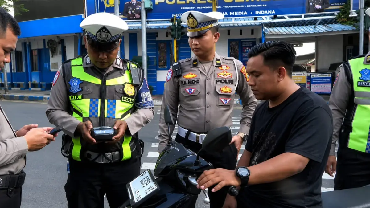 UJI COBA: Petugas Satlantas Polres Jember menertibkan pelanggaran pengendara dengan menggunakan etle handheld. (M. ADHI SURYA/RADAR JEMBER)
