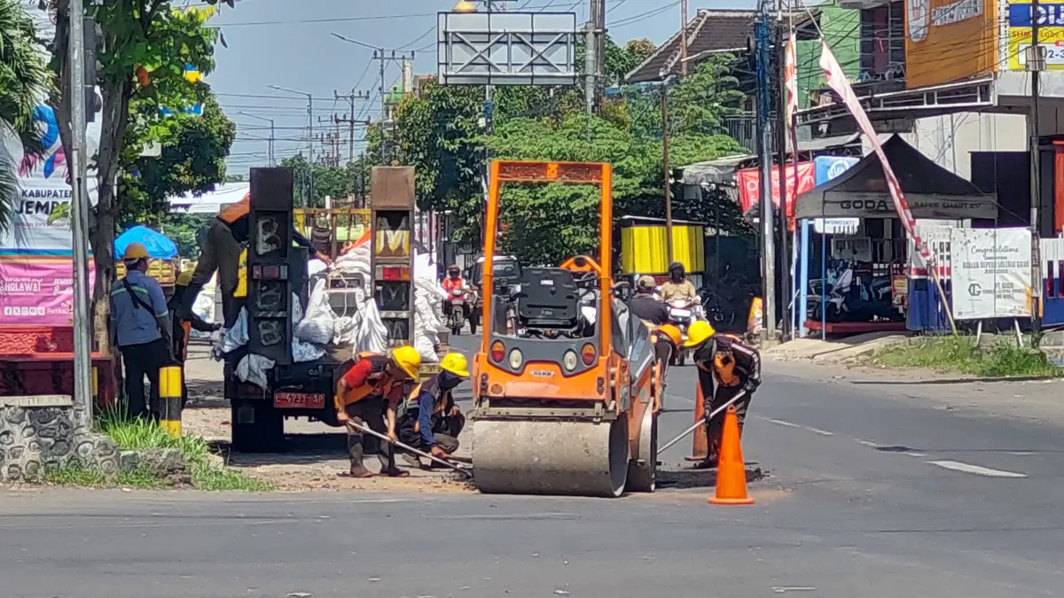 MUDAH-MUDAHAN BERTAHAN: Dinas PU Bina Marga Provinsi Jawa Timur melakukan penambalan jalan rusak depan Kantor Kecamatan Jenggawah.(JUMAI/ RADAR JEMBER)
