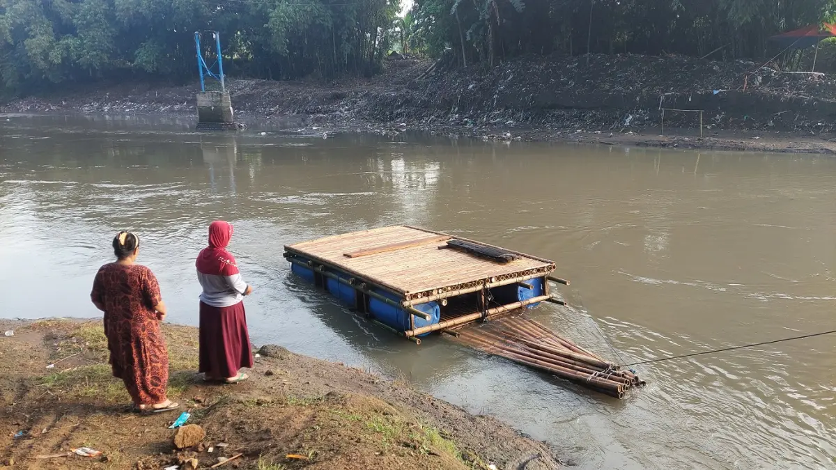 Warga dan siswa SDN Jubung 02 masih memanfaatkan getek bambu dan drum plastik untuk menyeberangi Sungai Bedadung setiap hari. (Jumai/Radar Jember)