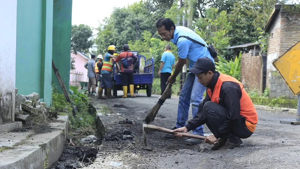 MEMPERBAIKI: Sejumlah pekerja saat memperbaiki jalan rusak yang dikerjakan oleh Pemkab Bondowoso. (FAQIH HUMAINI/RADAR IJEN)