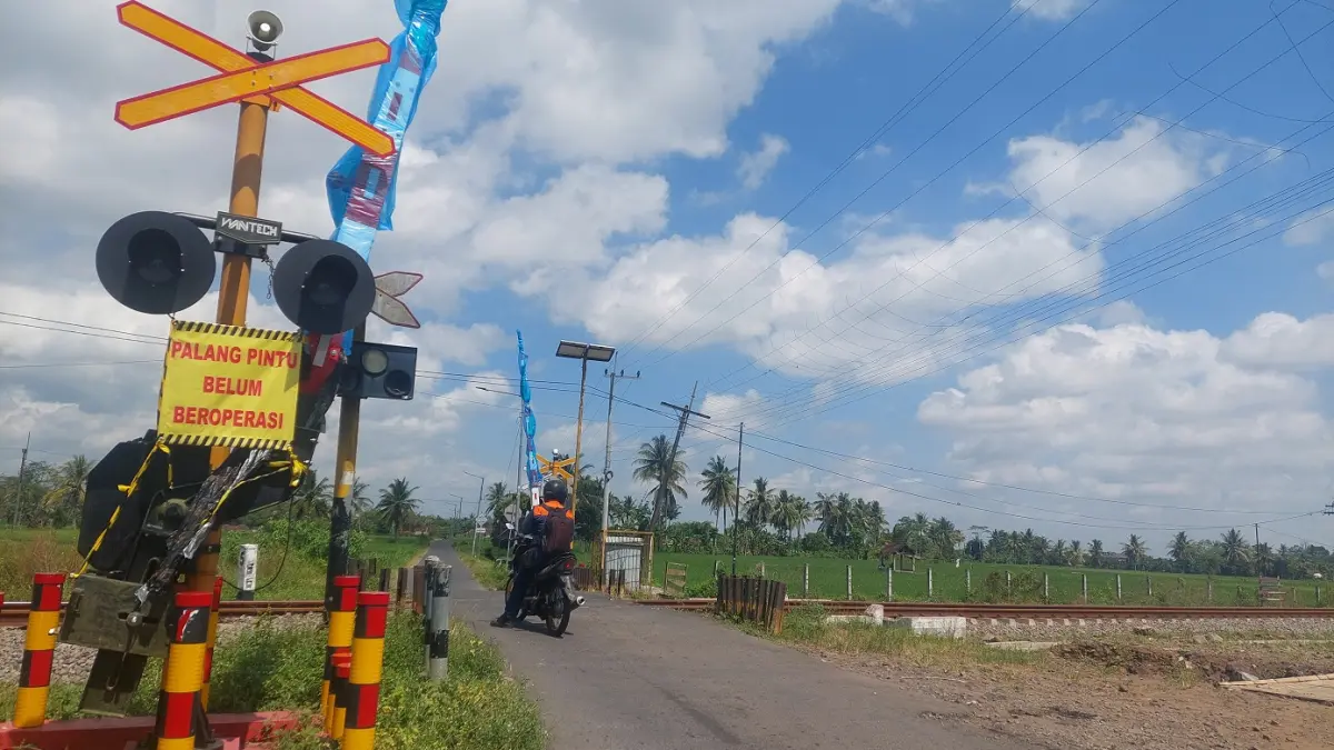 BELUM DIFUNGSIKAN: Perlintasan Kereta Api (KA) di Dusun Krajan, Desa Bedadung, Kecamatan Pakusari terdapat palang pintu yang masih baru. Sayangnya palang itu belum difungsikan. (JUMAI/RADAR JEMBER)