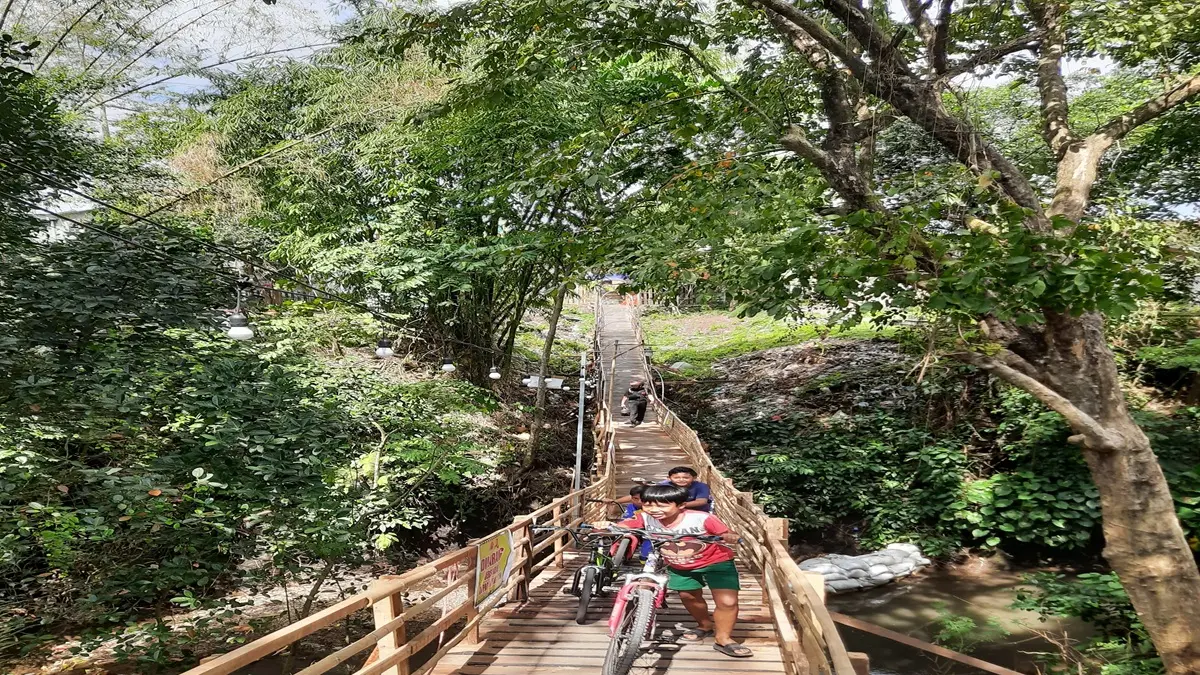 DILEWATI: Sejumlah warga saat melewati jembatan darurat sentong, kemarin (15/5).(FAQIH HUMAINI/RADAR IJEN)