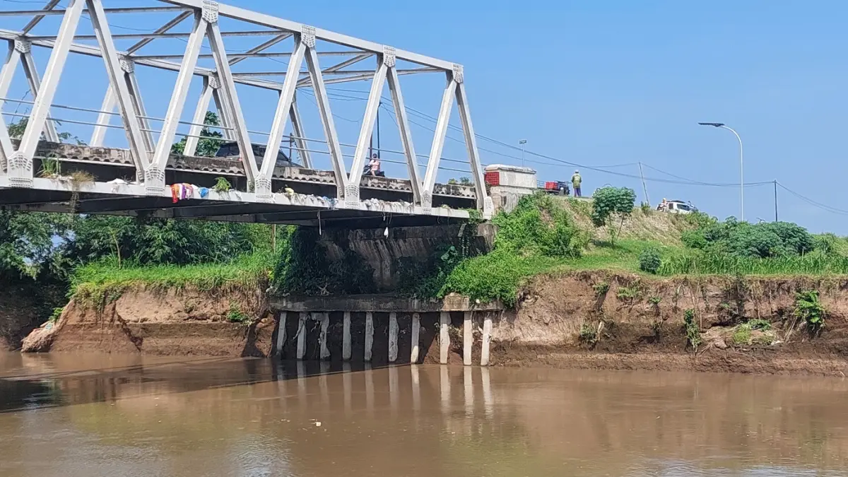 TERGERUS BANJIR: Kondisi pondasi jembatan yang menghubungkan Wuluhan dengan Puger tergerus saat sungai Bedadung banjir. (JUMAI/RADAR JEMBER)