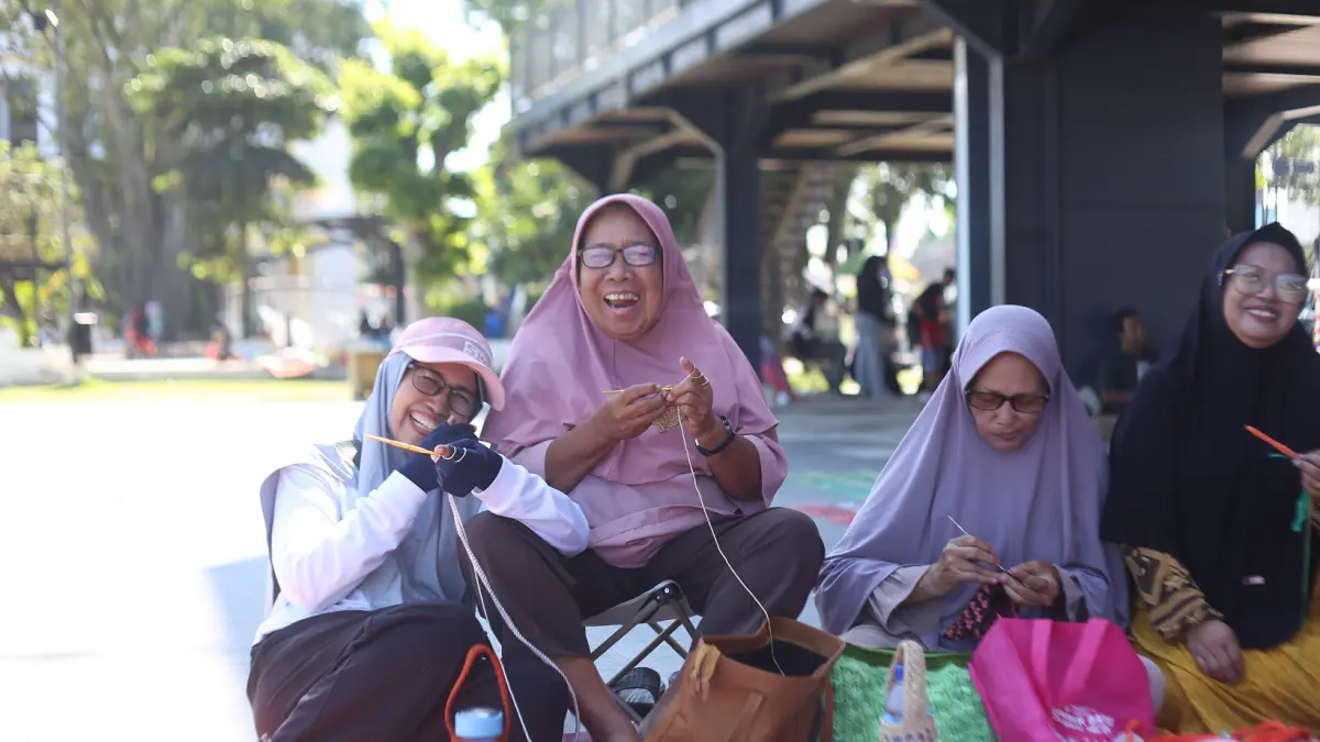 TEATP PRODUKTIF: Hartatik, 79, (kanan) pensiunan bidan RSD dr Soebandi, bersama temannya, Tasiyatun, 75, dan lainnya membuat kerajinan tangan di Alun-Alun Jember. (TRI JOKO S/RADAR JEMBER)