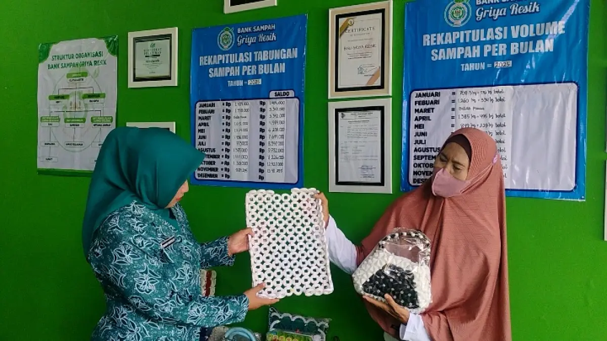 INSPIRATIF: Ely Yuliastutik (kanan) menunjukkan salah satu karya olahan hasil limbah plastik, melalui komunitas bank sampah yang diketuainya Unit Griya Resik, Kelurahan/Kecamatan Sumbersari, Jember. (DOK. DISKOMINFO)