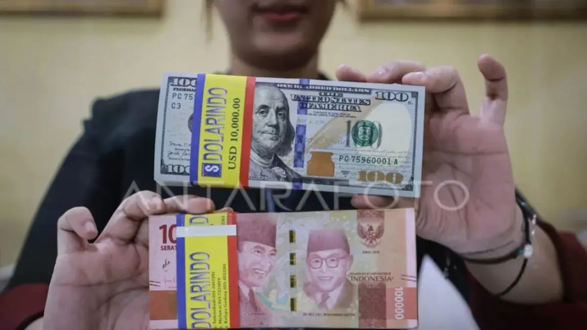 Petugas menunjukkan uang pecahan rupiah dan dolar AS di gerai penukaran mata uang asing Dolarindo, Melawai, Jakarta, Senin (15/9/2025).  (ANTARA FOTO/Dhemas Reviyanto)
