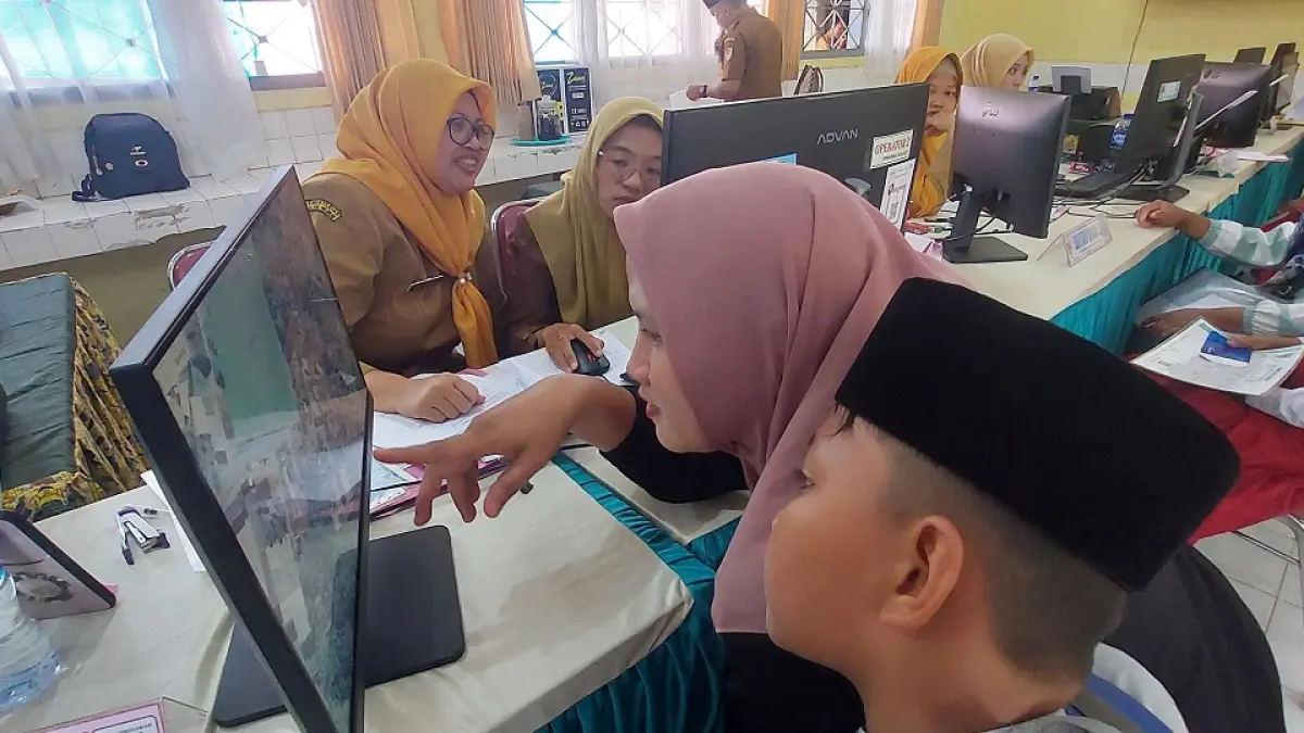 DAFTAR SEKOLAH: Seorang ibu mengantar putranya pada hari pertama SPMB di SMPN 1 Jenggawah, Senin (8/6) pagi. (JUMAI/RADAR JEMBER)