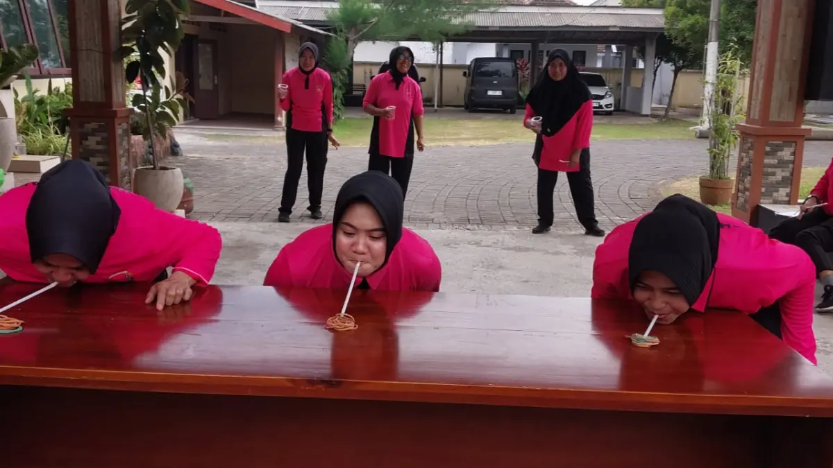 MERIAH: Ibu-ibu anggota Bhayangkari Polsek Sumberbaru, Jember saat mengikuti lomba ambil karet gelang menggunakan sedotan plastik Pada Jumat (12/6/2026). (JUMAI/RJ)
