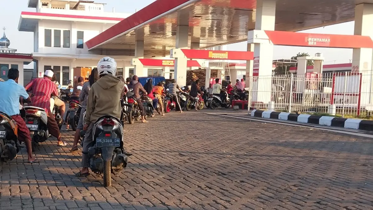 ANTRE: Kendaraan roda dua dan empat saat mengantre BBM Pertalite di SPBU, Wonojati, Jenggawah Senin (15/6). (JUMAI/ RADAR JEMBER)