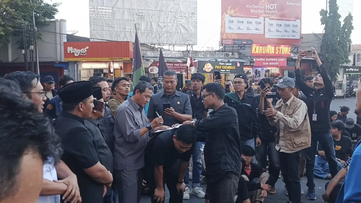 Empat pimpinan DPRD beserta perwakilan masing-masing fraksi DPRD Jember, saat menemui mahasiswa, dan menandatangani pakta integritas yang disodorkan tuntutan peserta aksi, di bundaran DPRD Jember (15/6). (Maulana/JPRJ)