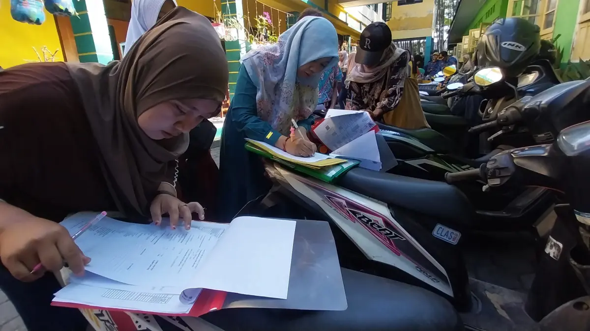 PENDAFTARAN SEKOLAH: Sejumlah orang tua melakukan daftar ulang setelah anaknya diterima SPMB SMP tahap pertama, kemarin (17/6). (JUMAI/ RADAR JEMBER)
