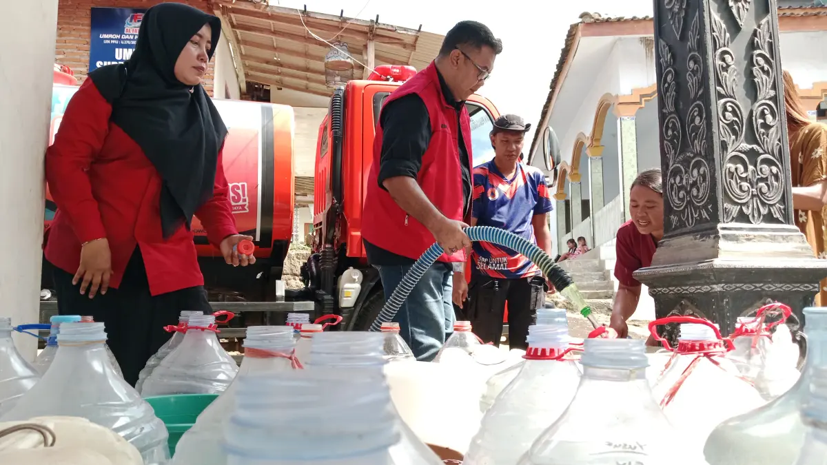 DIBERIKAN: Sinung Sudrajad saat mendistribusikan air bersih, Sabtu (13/6). (FAQIH HUMAINI/RADAR IJEN)