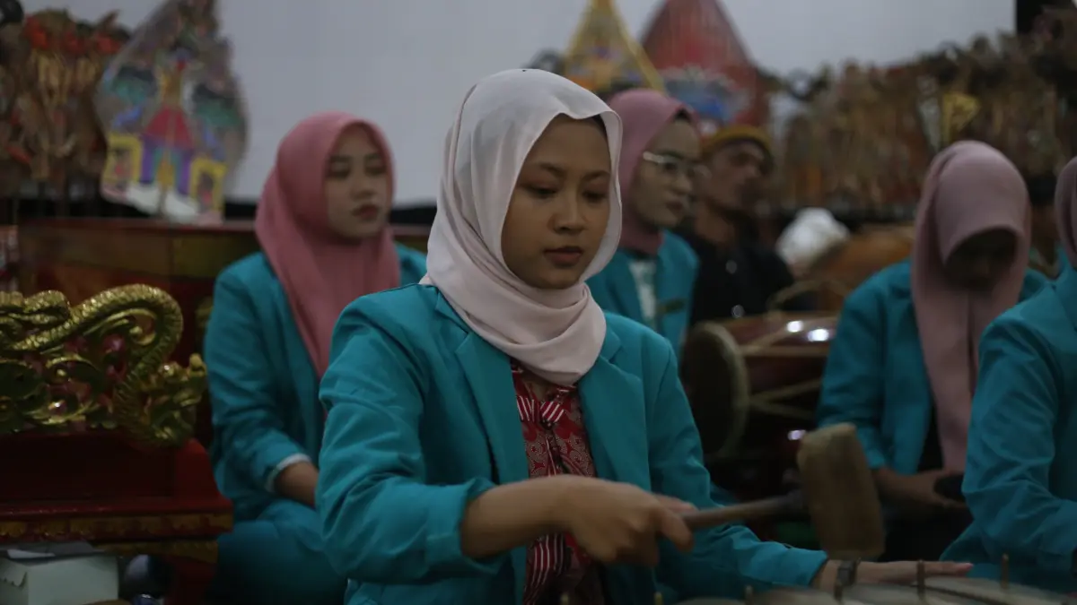LESTARIKAN BUDAYA: Al Azhiva Azzahra Wb, mahasiswi UDS pegiat musik tradisional unjuk kebolehannya menabuh gamelan. (M. ADHI SURYA/RADAR JEMBER)